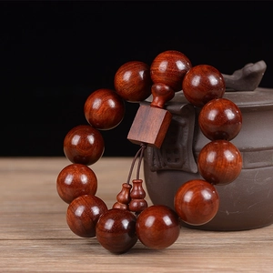 Detail of 20mm sandalwood beads with 12 grains showing natural red wood grain texture