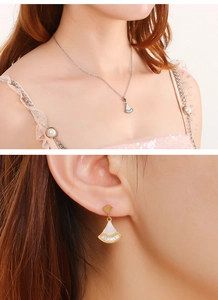 Détail de la parure coquillage en forme d'éventail avec collier argent et boucles d'oreilles