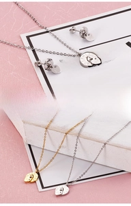 Close-up of heart and Roman numeral pendants on necklaces and earrings in gold and silver