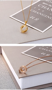 Detailed view of circular pendants with full rhinestones in gold and rose gold finishes
