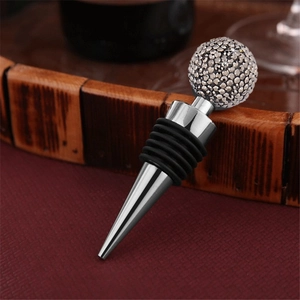Detailed close-up of a silver wine stopper featuring a sparkling rhinestone-studded crystal ball