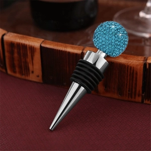 Detail of blue crystal ball wine stopper on wood with metallic cone and rubber seal