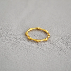 Close-up of a gold-plated brass ring featuring a modern bamboo joint design and open band