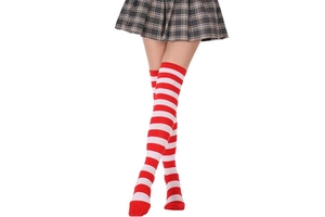 Détail de chaussettes hautes rayées rouges et blanches avec une jupe plissée grise