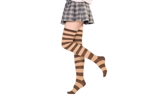 Détail de chaussettes hautes rayées marron et beige portées avec une jupe plissée