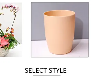 Détail d'un gobelet minimaliste en plastique orange utilisé comme pot de fleurs