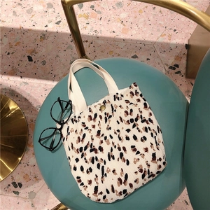 Dettaglio della mini borsa leopardata a pieghe con fibbia dorata e manici in tela