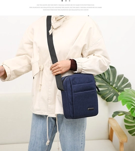 Man in casual outfit wearing a navy blue canvas crossbody bag with adjustable strap