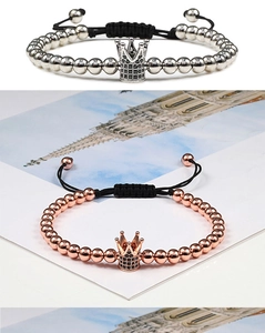 Detail of silver and rose gold crown bracelets with zircon inlay and black braided cords