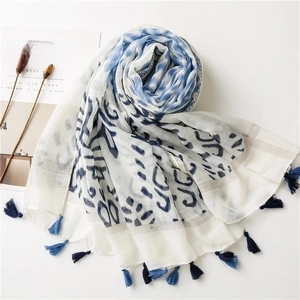 Detail of wave print scarf featuring deep blue tassels and breathable linen fabric