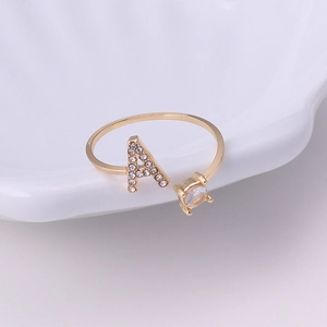 Macro shot of gold adjustable ring with crystal pavé letter A and round gemstone