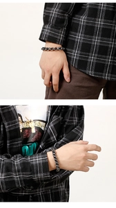 Detail of silver biker skull bracelet with intricate cross pattern and heavy chain links