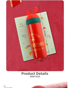 Close-up of red Christmas thermos with elk antlers and gold Merry Christmas text