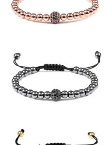 Detailed view of woven bracelets with metallic beads and micro-pave zircon spheres