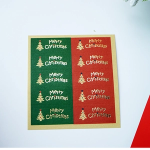 Detail of red and green Christmas tree stickers with gold foil Merry Christmas text