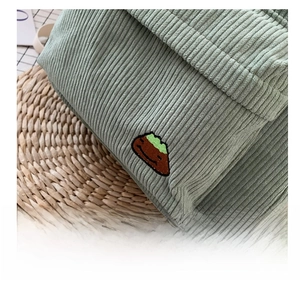 Detail of mint green corduroy fabric with small mountain embroidery on the backpack