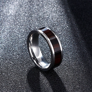 Men's silver stainless steel ring with dark wood grain inlay on textured black background