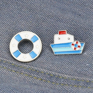 Nautical enamel pins set featuring a cartoon boat and lifebuoy on denim background