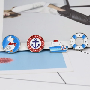 Detail view of four nautical enamel pins featuring duck, anchor, ship and lifebuoy designs