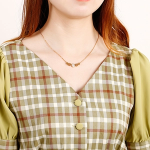 Élégant collier en acier inoxydable doré avec pendentif fleur en diamant sur un mannequin