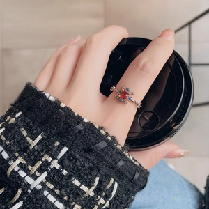 Detailed close-up of a vintage rose gold flower ring with ruby and blue sapphires