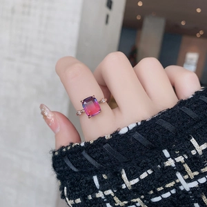 Macro detail of rose gold ring featuring a gradient rectangle crystal on a finger