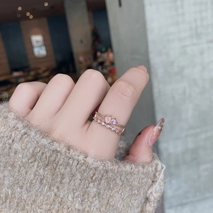 Close-up of rose gold ring set with heart-shaped pink stones and delicate pavé diamonds