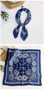 Detail view of a blue paisley silk scarf with a classic pattern and smooth texture