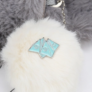 Detail of white faux fur keychain with light blue enamel charms and silver bead chain