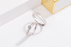 Close-up of silver adjustable couple rings with cubic zirconia stones on white props