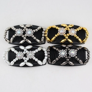 Detail of four magic hair combs with beads and rhinestone snowflake charms on grey background
