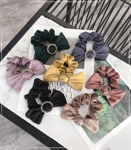 Detailed view of satin scrunchies with sparkling rhinestone buckle in various colors