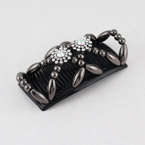 Close-up of black beaded hair comb with iridescent rhinestones and crystal accents