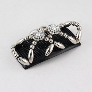 Detail of beaded magic hair comb with rhinestone flower patterns on silver metal chains