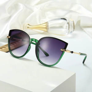 Vintage cat-eye sunglasses with green frames and purple gradient lenses on silk