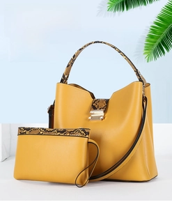 Detail of yellow bucket bag with snakeskin pattern strap and matching inner pouch