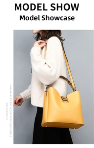 Detail of a bright yellow bucket bag featuring distinctive brown snake skin pattern accents