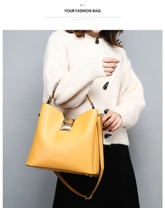 Fashionable yellow leather handbag featuring snake pattern handles and metallic lock