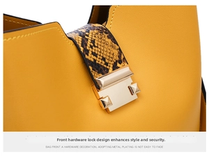 Detailed macro view of yellow leather handbag with gold metal lock and snake pattern strap