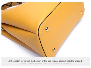 Detail of yellow leather bag base with golden protective studs and snakeskin strap