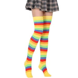Detail of colorful rainbow striped over-knee socks paired with a pleated plaid skirt