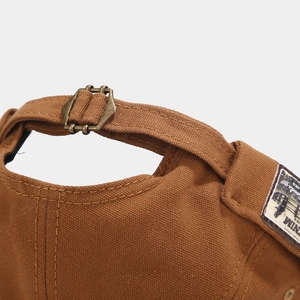 Detail of caramel canvas docker hat with vintage denim patch and metal adjustment buckle