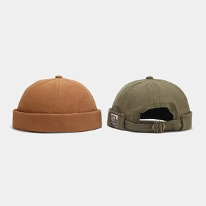 Retro brimless docker hats in brown and olive green with adjustable bronze metal buckles