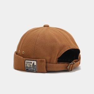 Detail of caramel canvas docker cap with side woven label and metal adjustment buckle