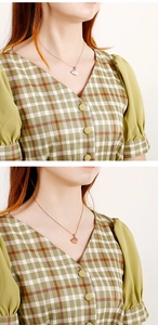 Close-up of elephant pendant necklace in silver and rose gold finishes on model