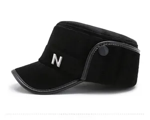 Detail of black winter flat top hat featuring plush faux fur and metal N-logo on side