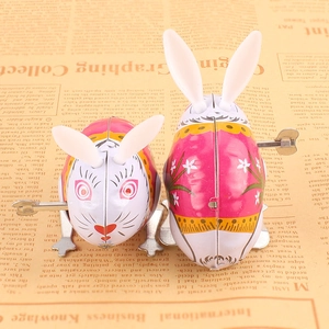Close-up of vintage tin clockwork jumping rabbit toys on newspaper background
