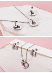 Detailed view of silver heart pendant necklace and matching stud earrings with rhinestones