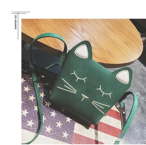 Detail of dark green cat-shaped crossbody bag featuring cute embroidery and velvet texture