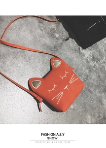 Detail of orange cat-shaped children cross-body bag with embroidery and 3D ears